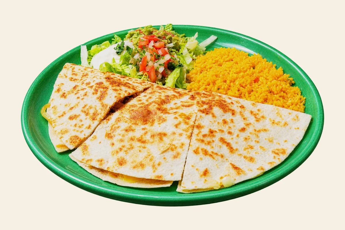 Chicken fajita quesadilla cut in wedges with Mexican rice, pico de gallo and guacamole