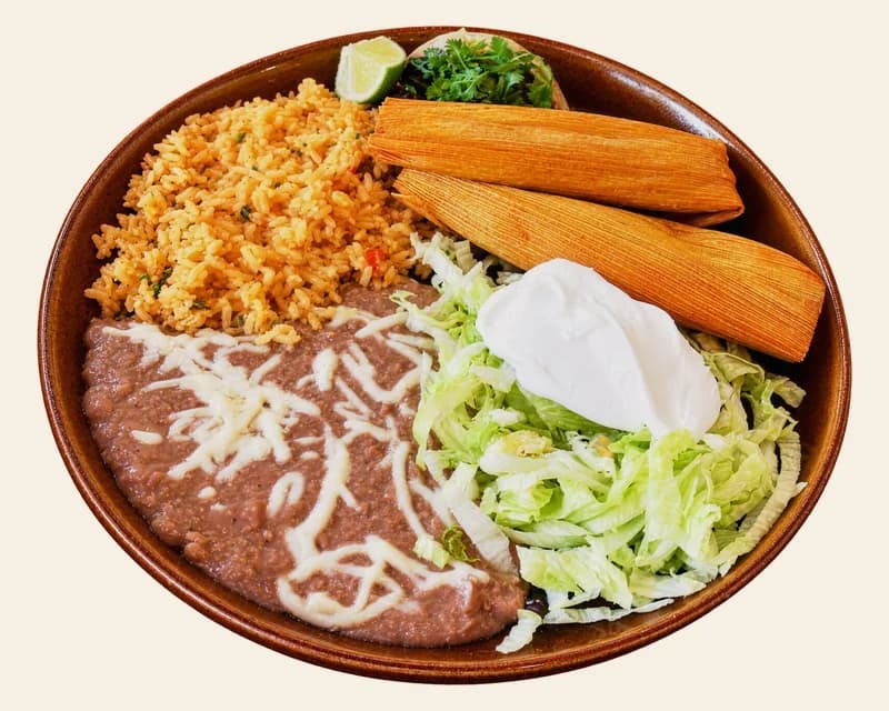 Two red chile pork tamales with rice, refried beans and lettuce